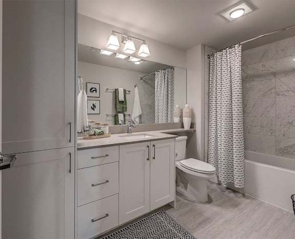 a bathroom with white cabinets and a shower and a toilet