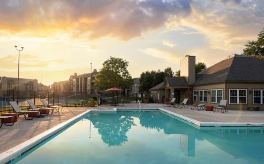 Swimming pool with crystal-clear water and lounge chairs by the side.
