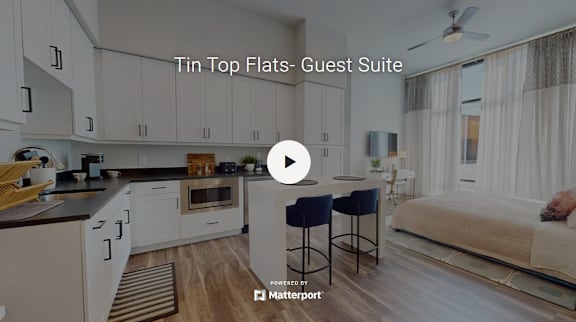 A video thumbnail showing a guest suite with a kitchen and a bed.