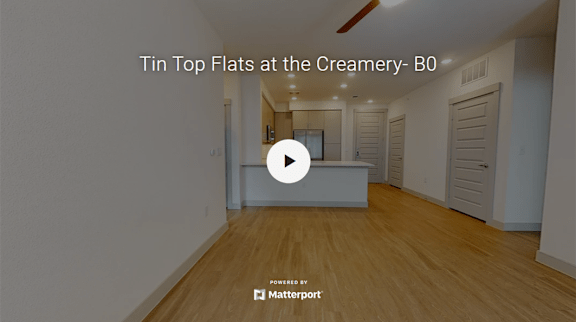 A room with wooden floors and white walls, titled "Tin Top Flats at the Creamery- B0".
