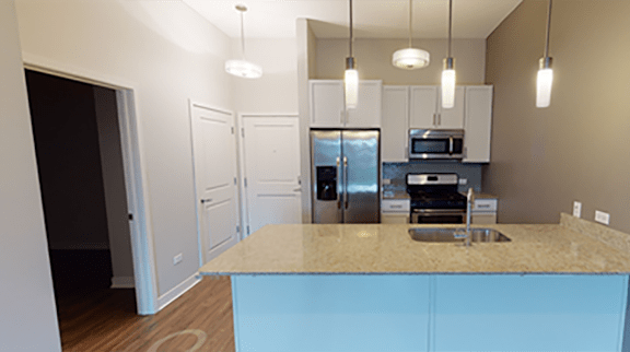 A kitchen with a sink, stove, and refrigerator.