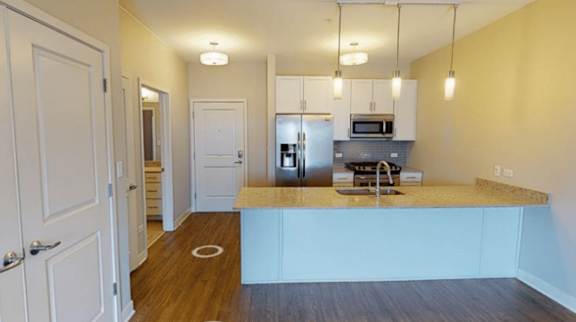 A kitchen with a white counter and a microwave on top.