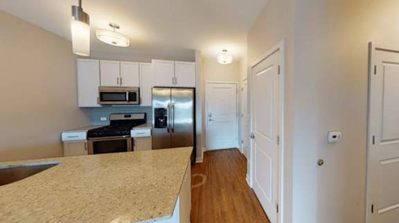 A kitchen with white cabinets and a stainless steel refrigerator.