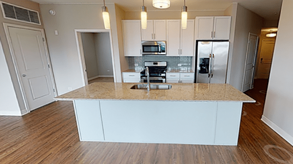 A kitchen with a granite countertop and white cabinets.