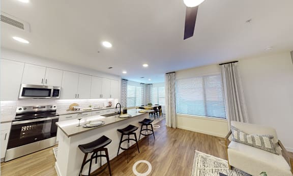 A modern kitchen with white cabinets and a large island.