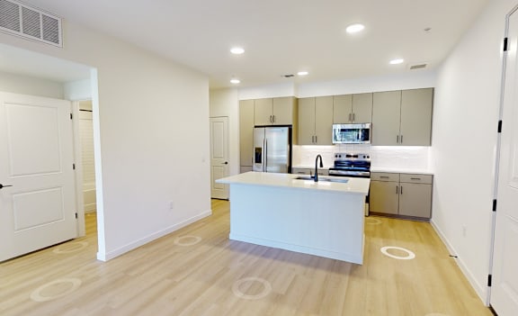 A kitchen with a white island in the middle of the room.
