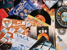 A pile of various old records and CDs.
