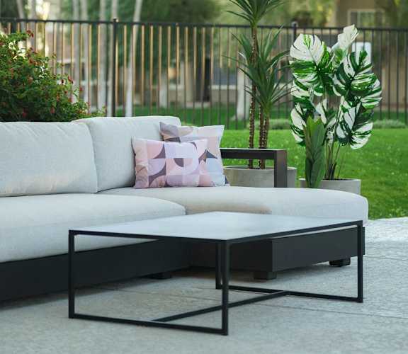 a living room with a couch and a coffee table on a patio