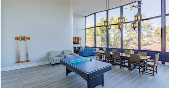 a living room with a ping pong table and a large window