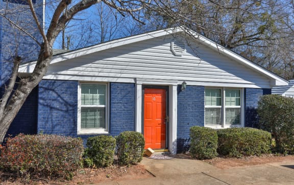 the front of a blue house with a red door