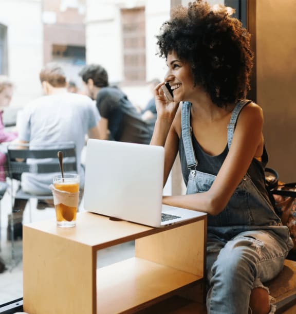 Woman sitting in a café with her laptop at Cobblestone apartments, Arlington, TX, 76011