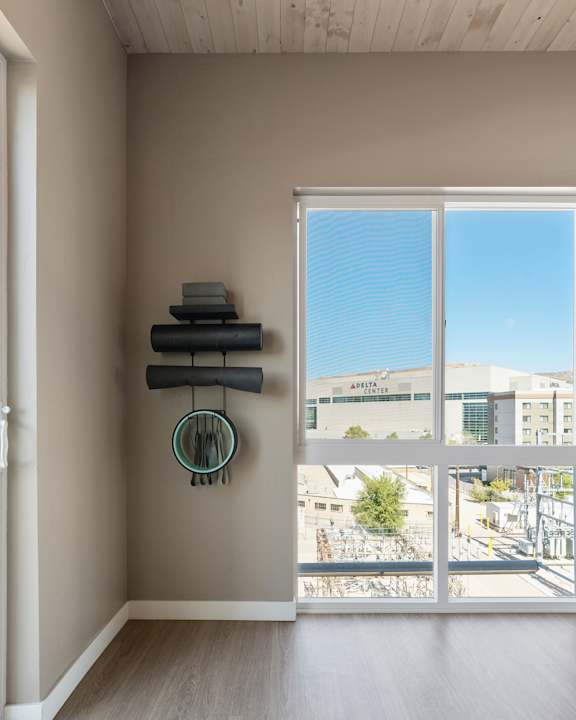 A room with a window overlooking a street and buildings.