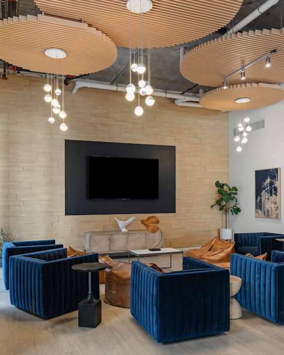 A modern living room with a flat screen TV mounted on a brick wall.