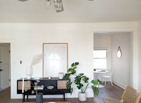 A living room with a black couch and a wooden chair.