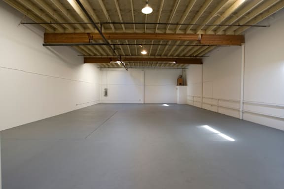 a large room with a concrete floor and white walls
