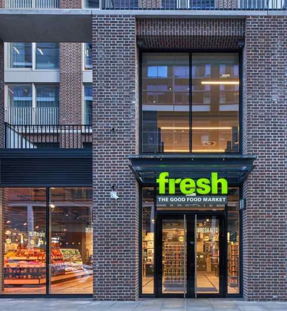 the front of a store with a green sign on a brick building
