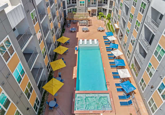 A large swimming pool surrounded by apartment buildings.