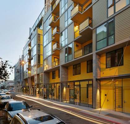 A modern apartment building with cars parked in front.