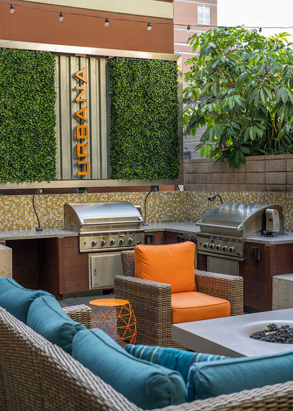 A patio with a grill and chairs.