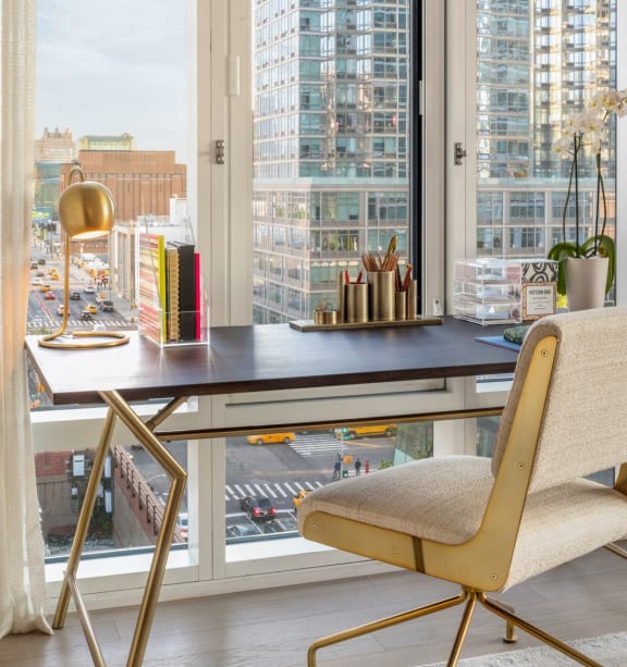 a home office with a desk and a view of the city