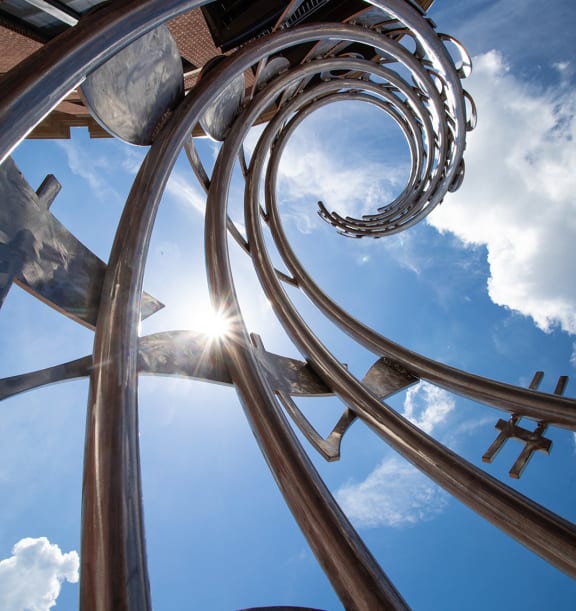 the sun shining through a metal sculpture with the sky in the background at Lyric at Norton Commons Apartments, Prospect, Kentucky