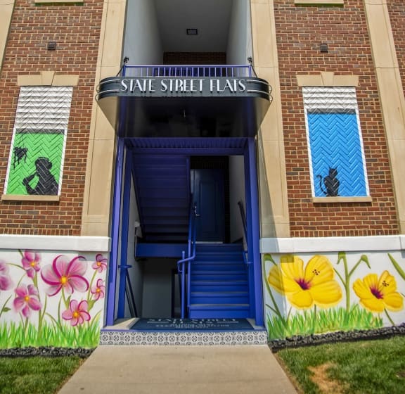 a building with a blue door and a mural on the side of it