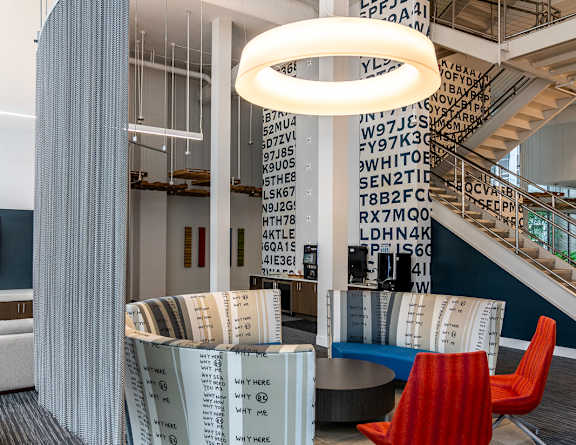 the lobby of a library with a red chair and a table