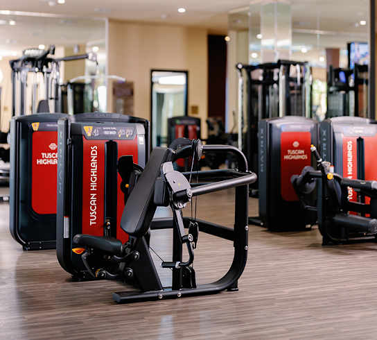A gym with a TUCK WORKSER machine in the foreground.