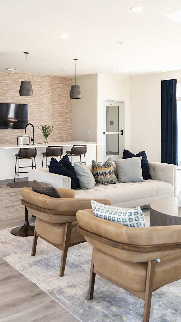 a living room with a couch and chairs and a kitchen at Forge65, Pleasant Hill, IA, 50327