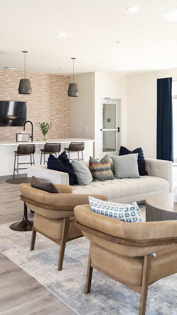 a living room with a couch and chairs and a kitchen at Forge65, Pleasant Hill, IA, 50327