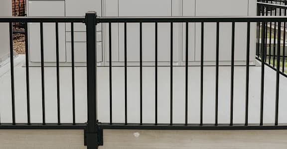 A white building with a black fence in front.