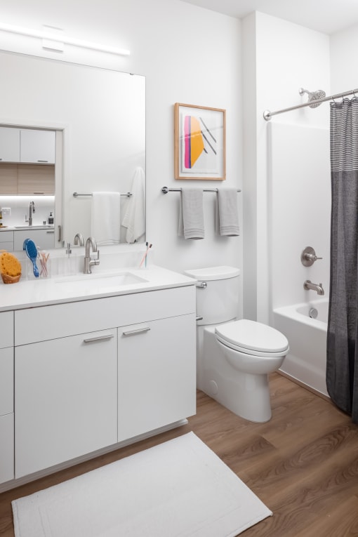 a bathroom with white cabinetry and a black shower curtain