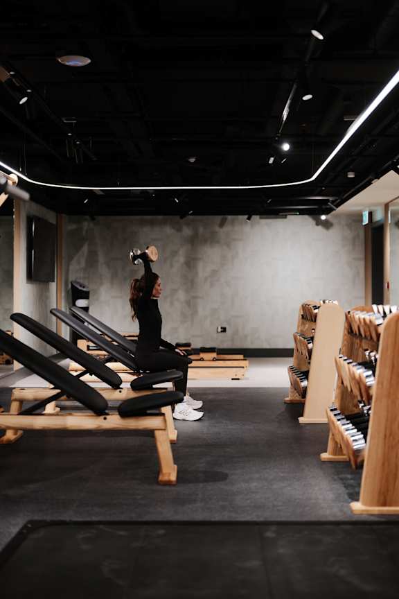 A man is running on a treadmill in a gym.