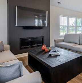 A modern living room with a fireplace and a flat screen TV mounted above it.