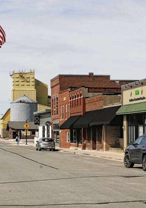 A street view of a small town with cars parked on the side of the road.
