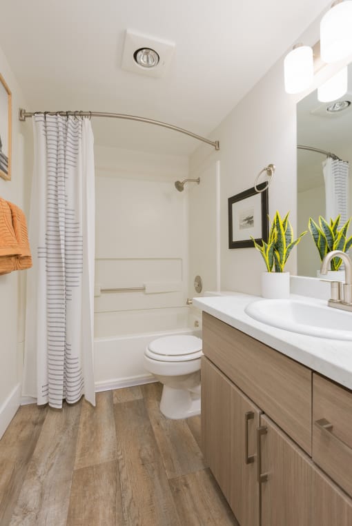 a bathroom with a toilet sink and shower in a 555 waverly unit
