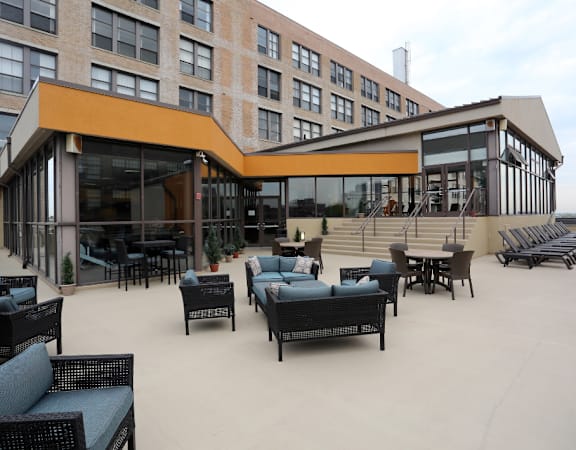 a large patio area with chairs and tables in front of a building