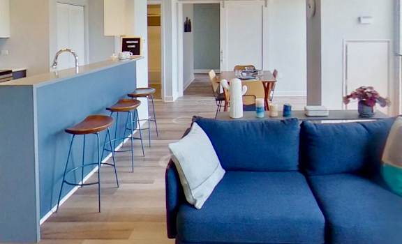 a blue couch in a living room next to a kitchen