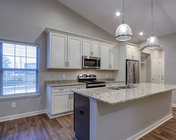 a kitchen with white cabinets and a granite counter top