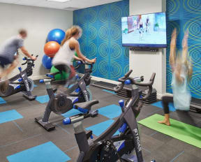 a group of people working out in a gym on exercise bikes