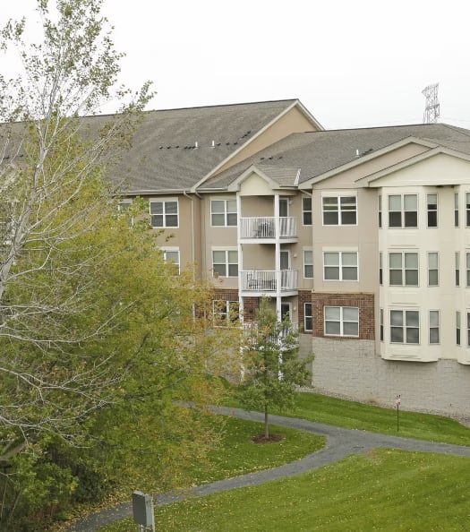 a large apartment building with balconies and a grassy area in front of it
