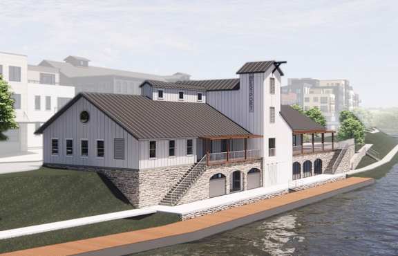 A modern house with a sloped roof is situated next to a body of water.