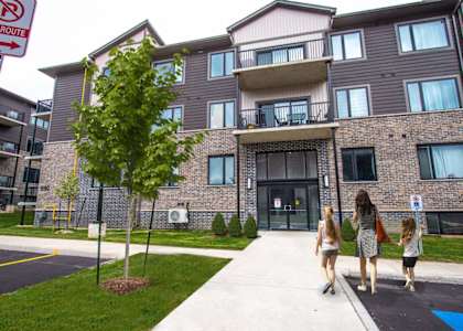 people walking in front of an apartment building