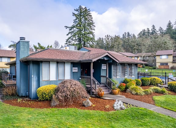 a blue house with a brown roof and a porch