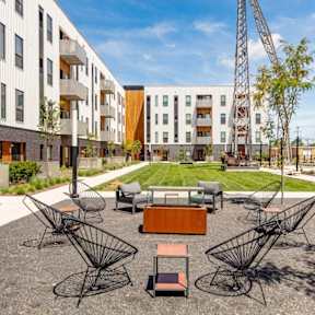 a courtyard with a table and chairs in front of an apartment building at Rowat Lofts, Iowa