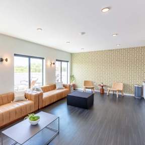 a living room with leather couches and a table at Rowat Lofts, Des Moines, IA