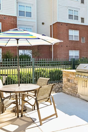 a patio with an umbrella and a table with chairs