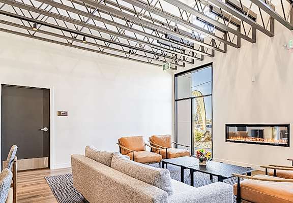 A living room with a grey couch and a fireplace.