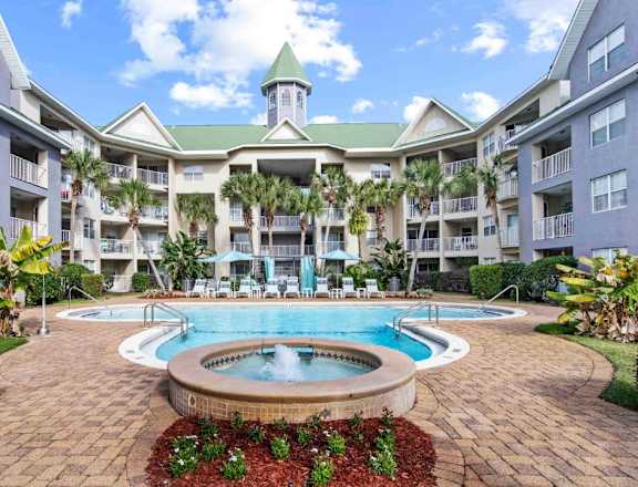 A large building with a green roof and a pool in front.at Coastline Apartments, Florida, 32547