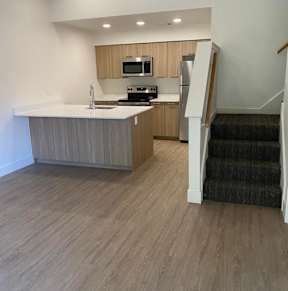 A kitchen with a staircase leading to the upper floor.